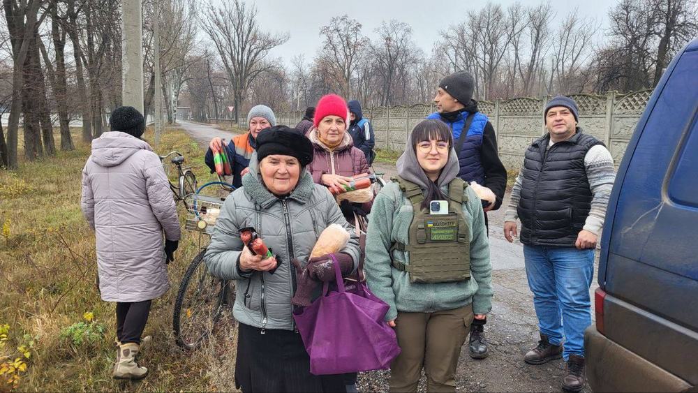 People receiving supplies outdoors in winter